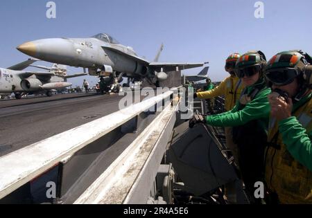 US Navy Aviation Boatswains Mate indique qu'un F-A-18 Hornet, affecté aux titraillieurs de l'escadron d'attaque de chasseurs de l'aile fixe un zéro cinq (VFA-105), est prêt à être lancé à bord du pont de vol à bord des États-Unis Banque D'Images