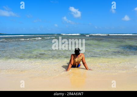 Une belle photo d'une jeune femme couverte de sable se détendant sur une plage Banque D'Images