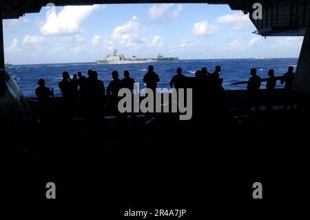 LES marins USS Kitty Hawk (CV 63) de la Marine AMÉRICAINE s'alignent dans la baie hangar pour observer les Kitty Hawk et les groupes de grève de John C. Stennis Carrier (CSG) se former pour un exercice photo Banque D'Images