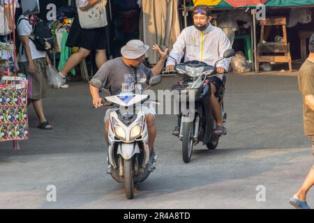 SAMUT PRAKAN, THAÏLANDE, 03 2023 MARS, deux hommes communiquent lorsqu'ils passent les uns les autres sur des motos Banque D'Images