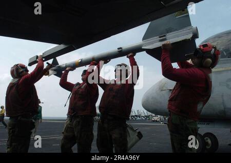 LES soldats DE l'aviation DE LA MARINE AMÉRICAINE chargent un missile air-air AIM-9 Sidewinder sur l'extrémité d'aile d'un F-A-18E Super Hornet Banque D'Images