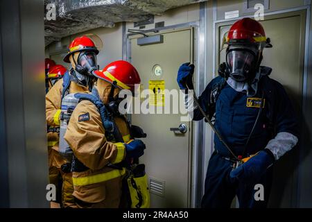 LES marins DE SINGAPOUR (15 mars 2023) effectuent une vérification de l'équipement lors d'un exercice de contrôle des dommages à bord du navire de combat littoral de classe Independence USS Oakland (LCS 24) à la base navale de Changi, Singapour, 15 mars 2023. Oakland, qui fait partie de l'escadron 7 de Destroyer, est en cours de déploiement par rotation, opérant dans la zone d'opérations de la flotte américaine 7th afin d'améliorer l'interopérabilité avec les alliés et les partenaires et de servir de force d'intervention en appui à une région Indo-Pacifique libre et ouverte. Banque D'Images