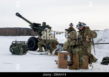 ÉTATS-UNIS Parachutistes de l'armée assigés à Alpha Battery, 2nd Bataillon, 377th parachutisme Field Artillery Regiment, 2nd Infantry Brigade combat Team (Airborne), 11th Airborne Division, homme a M119 105mm Howitzer à la zone de chute de Husky dans la zone d'entraînement du Yukon, ft. Wainwright, Alaska, 29 mars 2023, pendant le Centre de préparation multinational conjoint du Pacifique-Alaska 23-02. Le JPMRC-AK 23-02 aide les soldats et les dirigeants à élaborer et à affiner les tactiques, techniques et procédures nécessaires pour fonctionner avec succès dans des conditions d'hiver arctiques éloignées et extrêmes et pour surmonter les défis environnementaux et militaires. Banque D'Images