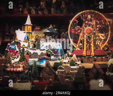 Une scène de Noël festive de petites décorations de village placées devant une grande roue de ferris colorée Banque D'Images