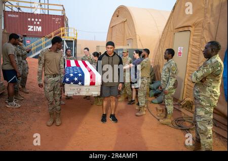 Les aviateurs de l'escadron de la base aérienne expéditionnaire 768th, vol de services, s'entraînent à porter correctement une boîte de transfert de restes humains pendant l'entraînement aux affaires mortuaires à l'AB 101, Niger, 4 avril 2023. Des aviateurs formés à prendre soin du membre du service décédé, notamment en portant correctement la boîte de transfert des restes humains et en drageant le drapeau. Banque D'Images