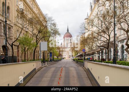 Une grande structure blanche se dresse en évidence à côté d'une rue pittoresque bordée d'arbres luxuriants et verts Banque D'Images