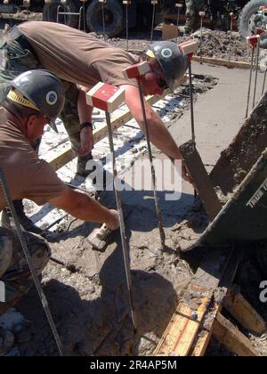 US Navy Builder 1st Class Left, et Builder 3rd Class from Naval Mobile Battalion One (NMCB-1) One, Gulfport, Muns, travaillent sur la fondation d'une école de trois pièces en cours de construction a Banque D'Images