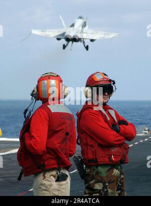 LE chef de l'aviation DE LA MARINE AMÉRICAINE, le compagnon de Boatswain, à gauche, et le compagnon de classe 1st de la Marine aérienne, observent les opérations du pont de vol Banque D'Images