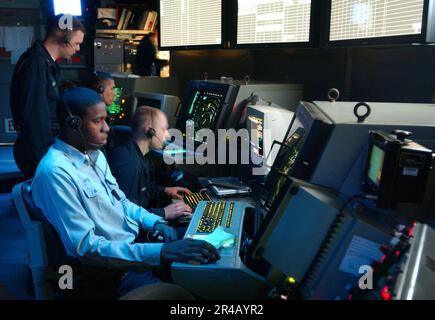 US Navy Air Traffic Controller 2nd Class debout, forme le contrôleur de trafic aérien Airmen Vector sur des oscilloscopes dans le centre de contrôle de la circulation aérienne Carrier à bord de l'avion de classe Nimitz carr. Banque D'Images