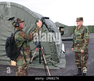 US Navy U.S. La classe 1st du journaliste de la Marine apporte des ajustements finaux à sa caméra vidéo lorsqu'il se prépare à interroger le commandant des États-Unis Armée du Pacifique, lieutenant-général John M. Brown III Banque D'Images