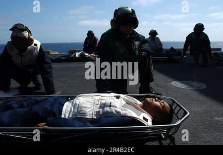 LES membres de la Marine AMÉRICAINE des services médicaux et dentaires du porte-avions USS Ronald Reagan (CVN 76) de la classe Nimitz, ainsi que les membres de l'équipage du pont de vol, se tiennent à côté pour transférer les patients du pont de vol. Banque D'Images