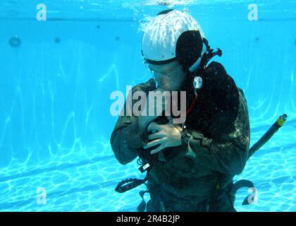 US Navy Un étudiant qui participe au cours de recyclage sur la survie de l'eau au centre d'entraînement de survie de l'aviation, Marine corps Air Station Miramar, gonfle oralement son gilet de survie. Banque D'Images