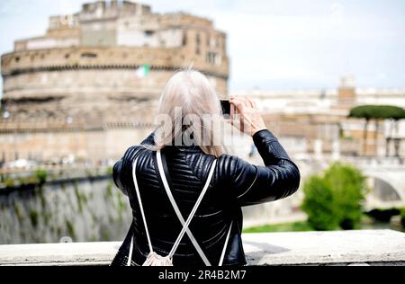 Un touriste prend une photo du Castel Sant'Angelo à Rome avec un smartphone Banque D'Images