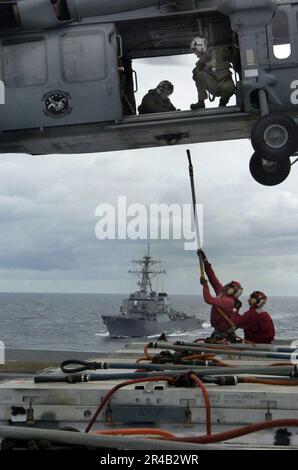 Le personnel du département DES armes DE la Marine AMÉRICAINE affecté à bord de l'USS Kitty Hawk (CV 63) se prépare à décharger l'équipement d'un MH-60s Knighthawk de l'Escadron de soutien de combat de la mer d'hélicoptère deux-cinq (HCS-25) pendant un ver. Banque D'Images