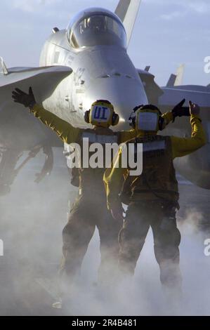 US Navy un directeur d'avion sous instruction, à gauche, taxis un F-A-18C Hornet. Banque D'Images