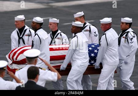 LES pallers DE la Marine AMÉRICAINE de la Garde d'honneur de cérémonie portent le cercueil du vice-ADM à la retraite lors d'un service commémoratif tenu à bord du porte-avions de la classe Nimitz USS Ronald Reagan (CVN 76). Banque D'Images