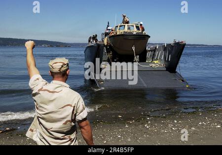 Les marins DE la Marine AMÉRICAINE affectés au maître de plage l'unité 1 dirige un embarcation d'atterrissage qui livre de l'équipement et des fournitures à Naval Magazine Indian Island pour préparer l'exercice de logistique interarmées sur la côte (JLOTS). Banque D'Images