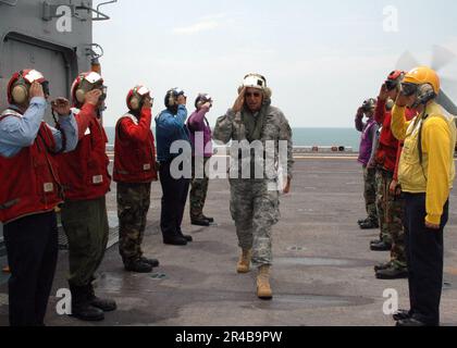 Commandant DE la Marine AMÉRICAINE, Force opérationnelle interarmées Katrina, États-Unis Le général de l'armée Russel Honoré salue alors qu'il marche à travers des cobays arc-en-ciel sur le pont de vol à bord du navire d'assaut amphibie USS Bataan (LHD 5). Banque D'Images
