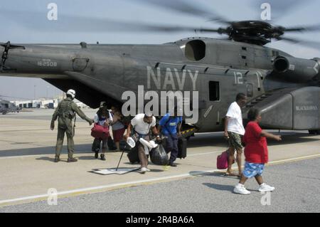 US Navy U.S. Des équipages de la Marine affectés à l'escadron des contre-mesures de la mine d'hélicoptères un cinq (HM-15) stationnés à la base aérienne navale de Corpus Christi, Texas, aident les victimes d'ouragans à sortir d'un hélicoptère MH-53E. Banque D'Images