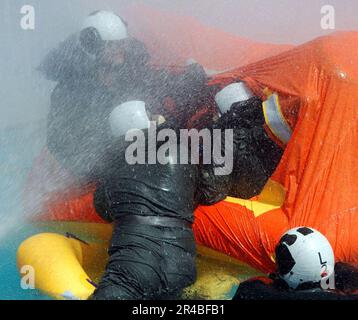 LE crewman d'air DE la Marine AMÉRICAINE s'aide mutuellement dans un radeau de sauvetage de 12 hommes pour attendre une simulation de sauvetage dans la piscine au centre d'entraînement de survie de l'aviation (ASTC) Miramar. Banque D'Images