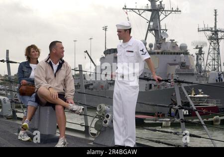 LA classe 3rd du technicien SONAR DE la Marine AMÉRICAINE parle avec les membres de la famille avant de commencer une croisière d'une journée entre amis et en famille. Banque D'Images