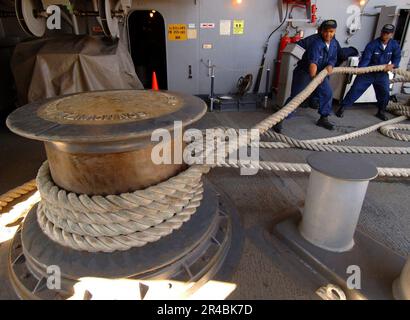 Les marins DE la Marine AMÉRICAINE affectés au département de pont tirent une ligne d'amarrage tandis que le porte-avions de la classe Nimitz USS Harry S. Truman (CVN 75) sort de la base navale de Norfolk. Banque D'Images