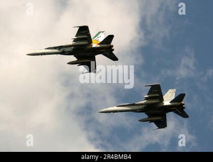 US Navy deux F-A-18C Hornets, affectés au Dambusters of Strike Fighter Squadron un neuf cinq (VFA-195), volent le long du porte-avions classique USS Kitty Hawk (CV 63). Banque D'Images