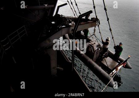 LES marins DU département DU pont DE LA MARINE AMÉRICAINE stationnés à bord du porte-avions de la classe Nimitz USS John C. Stennis (CVN 74), élèvent un bateau gonflable à coque à passagers (RHIB) de l'eau. Banque D'Images