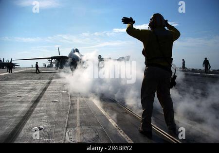 LE compagnon de Boatswain, chef de l'aviation DE LA MARINE AMÉRICAINE, dirige un F-14D Tomcat en position de lancement. Banque D'Images