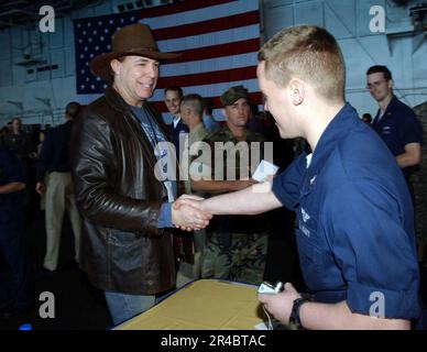 LE chanteur DE musique country DE LA MARINE AMÉRICAINE Michael Peterson serre la main avec un membre de l'équipage à bord du porte-avions de classe Nimitz USS Theodore Roosevelt (CVN 71). Banque D'Images