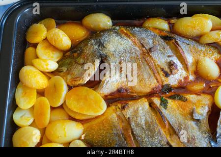 Gros plan d'une dorade grillée avec pommes de terre et sauce Banque D'Images