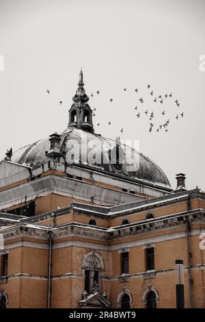 Un gratte-ciel moderne se dresse contre le ciel, avec une grande structure de dôme située au premier plan Banque D'Images