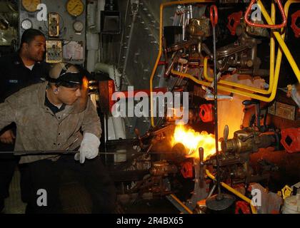 LA classe machiniste US Navy Mate 2nd supervise alors que le pompier se prépare aux feux de lumière. Banque D'Images