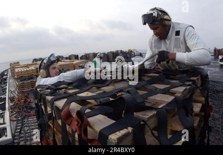 LES marins DE la Marine AMÉRICAINE stationnés à bord du porte-avions de la classe Nimitz USS Theodore Roosevelt (CVN 71) sécurisent la cargaison à transporter. Banque D'Images