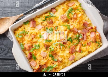 Des pâtes au jambon autrichien cuites au four, appelées Schinkenfleckerl, se ferment sur le plat de cuisson sur la table. Vue horizontale du dessus Banque D'Images