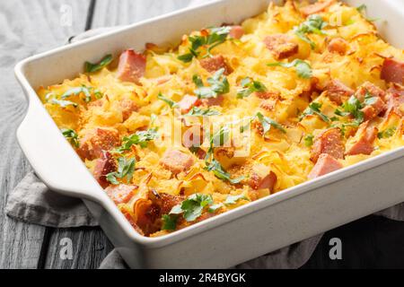 Des pâtes au jambon autrichien cuites au four, appelées Schinkenfleckerl, se ferment sur le plat de cuisson sur la table. Horizontale Banque D'Images