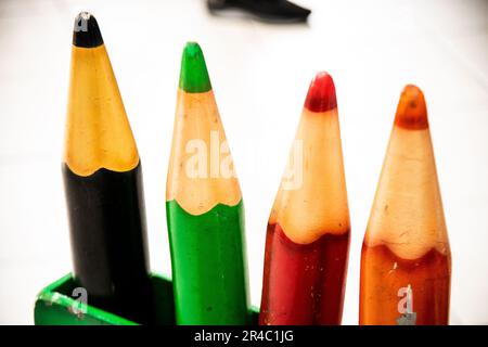 Un ensemble de crayons de couleur vive soigneusement disposés dans un support en bois placé sur un plan d'examen Banque D'Images