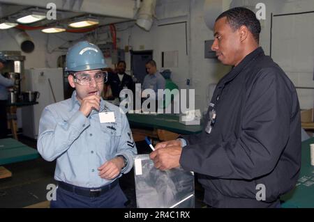 LA classe US Navy Machinist Mate 2nd prélève un échantillon d'ADN de sa bouche avec un coton-tige dans le cadre d'un entraînement de moelle osseuse. Banque D'Images