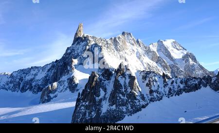 Photo aérienne d'une chaîne de montagnes enneigée, avec une grande montagne située entre les autres sommets Banque D'Images