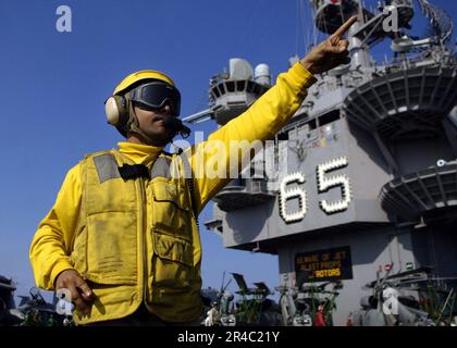 LE compagnon de Boatswain, chef DE l'aviation DE LA MARINE AMÉRICAINE, dirige l'avion sur le pont de vol à bord du porte-avions à propulsion nucléaire USS Enterprise (CVN 65). Banque D'Images