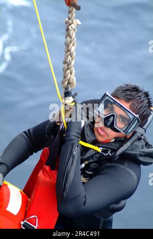 LE nageur DE recherche et sauvetage (SAR) de la Marine AMÉRICAINE est transporté à bord du quai amphibie USS Harpers Ferry (LSD 49) lors d'un exercice de remise en état. Banque D'Images