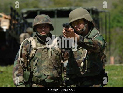 US Navy U.S. La journaliste de la Marine 2nd classe pratique son but, tandis que les États-Unis Le Sgt. Maître de la Force aérienne sert d'entraîneur de file Banque D'Images
