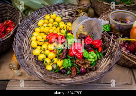 Un assortiment de fruits et légumes frais et vivants présentés dans des paniers en osier avec couvercles en plastique Banque D'Images