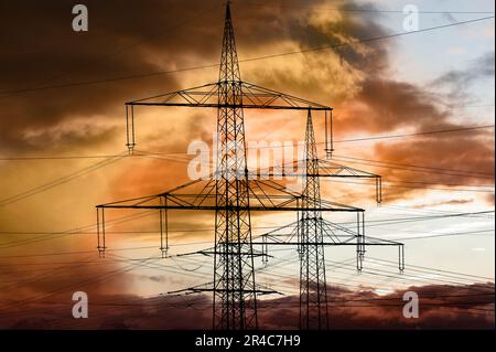 pylônes électriques haute tension contre le ciel avec des nuages spectaculaires Banque D'Images