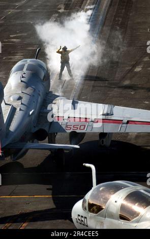 US Navy un pilote d'avion dirige un US Navy Marine corps EA-6B Prowler en position de lancement à bord du porte-avions de la classe Nimitz USS Ronald Reagan (CVN 76).