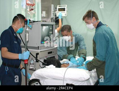 CMDR. LT. MARINE US À droite, l'hôpital Corpsman 3rd classe gauche) et l'Hospitalman se préparent à effectuer une endoscopies sur un patient blessé recevant sur le Sealif militaire. Banque D'Images