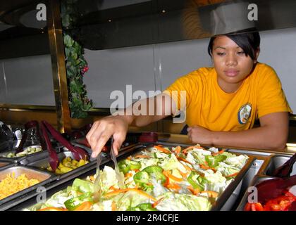 LE Matte Seaman Juntine R. Velayo de la MARINE AMÉRICAINE Gunner de Las Vegas, au Nevada, prépare le buffet de salades dans le mess de la salle des gardes à bord de l'assaut amphibie USS Iwo Jima (LHD 7). Banque D'Images