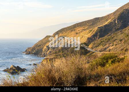 Vue sur la côte sauvage de la Californie partiellement enveloppée de brouillard qui s'étend de l'océan au coucher du soleil en automne Banque D'Images