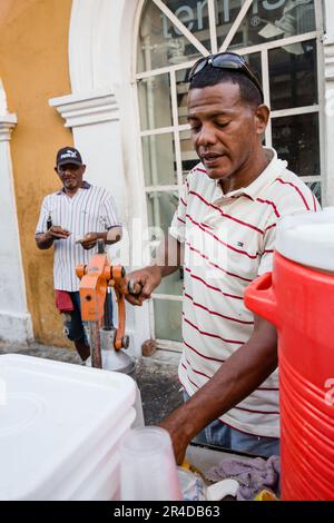 Un homme vend du jus de fruits frais pressé à partir d'un chariot dans la vieille ville de Cartagena, Colombie Banque D'Images