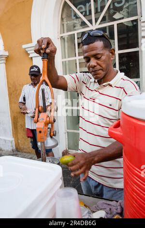 Un homme vend du jus de fruits frais pressé à partir d'un chariot dans la vieille ville de Cartagena, Colombie Banque D'Images